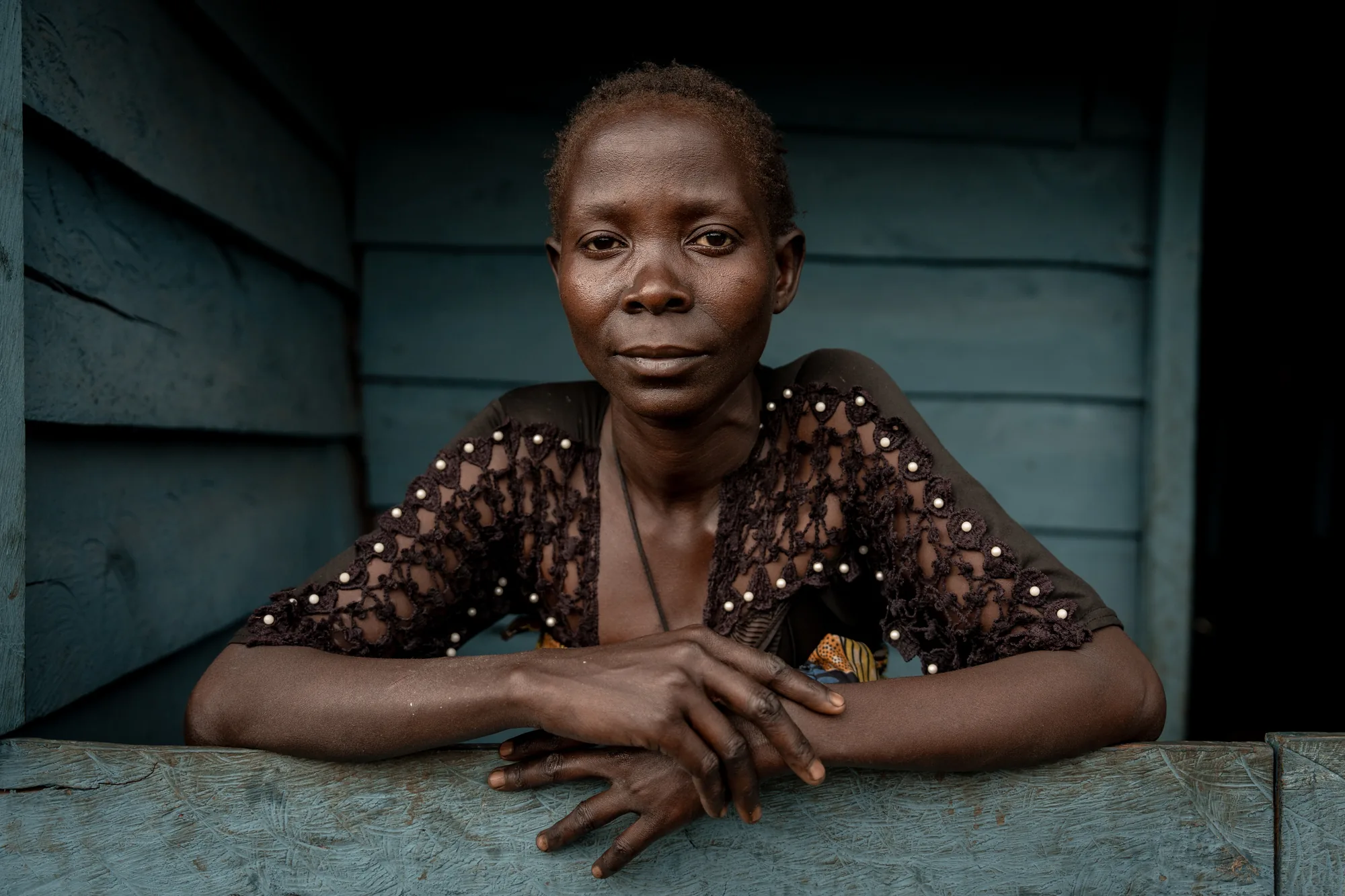 In eastern Democratic Republic of the Congo, Kacha Zawadi Maombi, a mother of five from an indigenous community, in her newly rebuilt home. Replacing a house destroyed by bombing, it provides her family with safety, privacy and dignity.