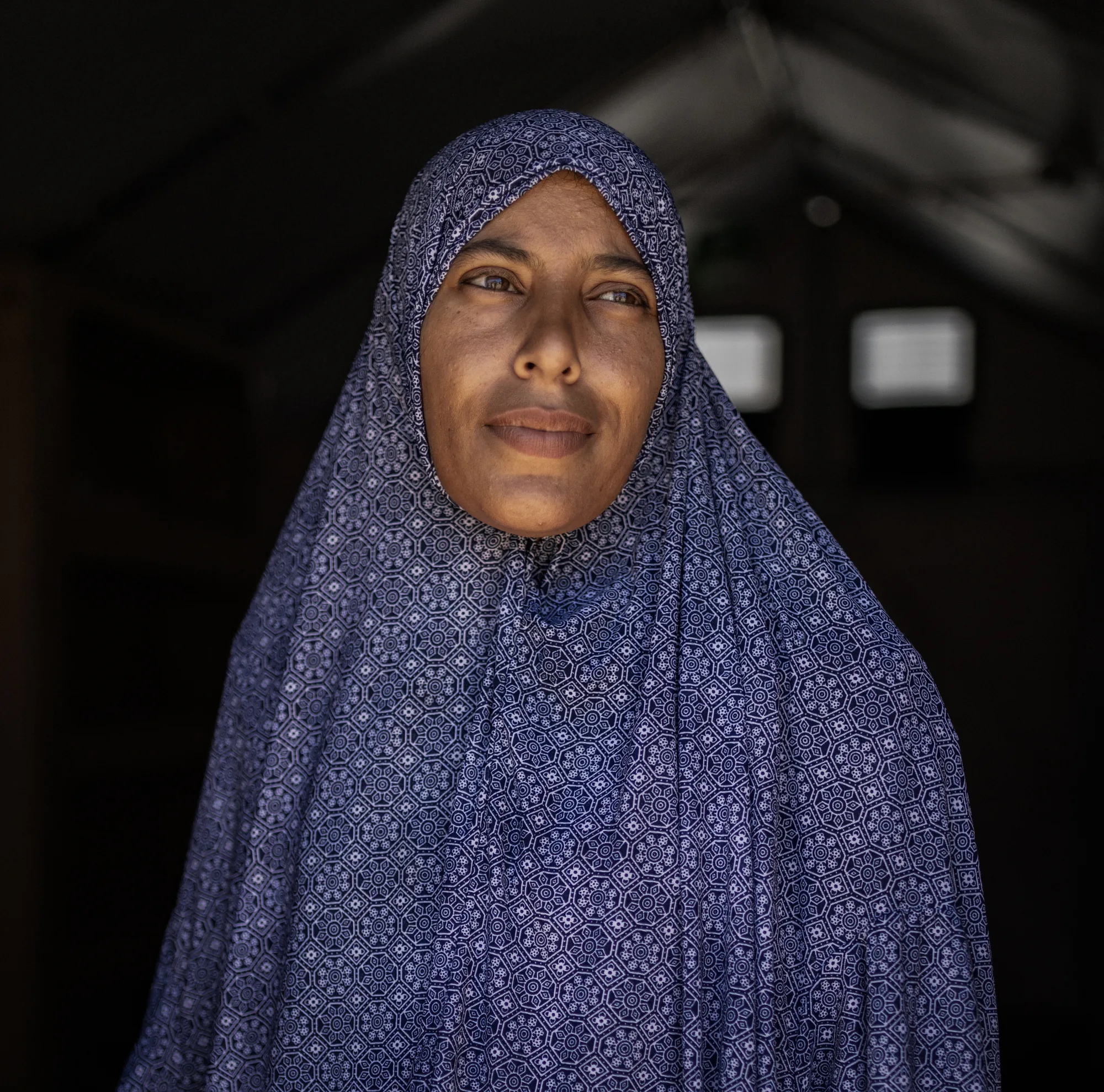 Amna stands inside her family’s transitional shelter in Gaza. After living in a damaged tent, the new housing unit gives her family greater privacy and protection, creating a safer space during prolonged displacement.