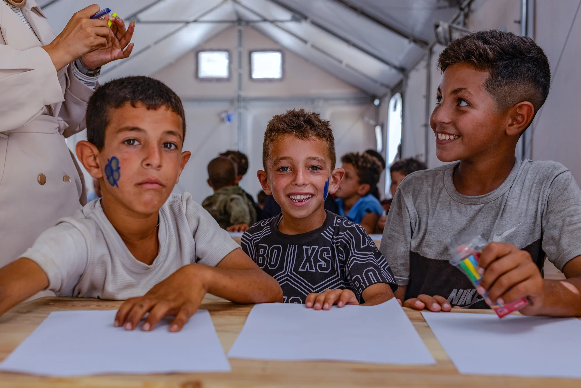 In Khan Younis, Gaza, children take part in a drawing activity in a safe space after months of war. Activities like these help them reconnect with routines, creativity and a sense of security amid ongoing uncertainty.