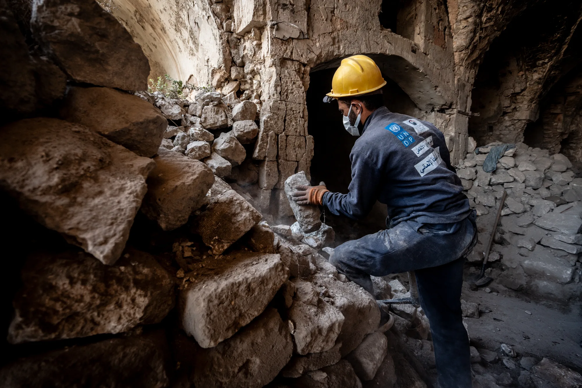 In Aleppo’s Old City, a cash-for-work labourer removes debris left by years of conflict in Syria. The work provides income for families while helping restore streets, homes, and businesses.